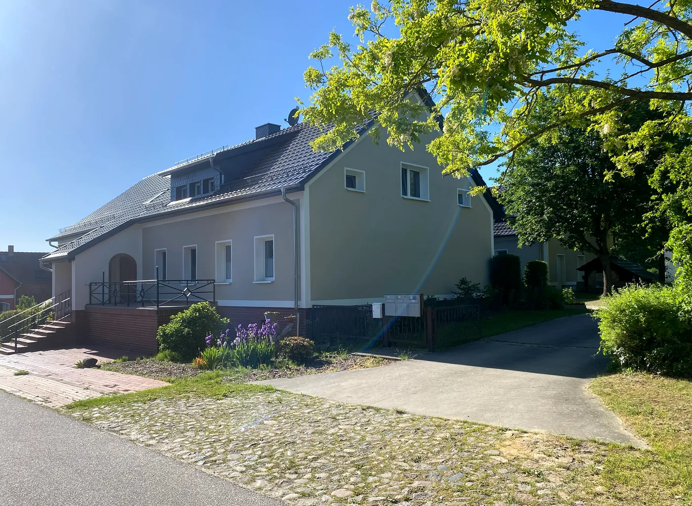 Seitliche Hausansicht mit Garten und Zufahrt