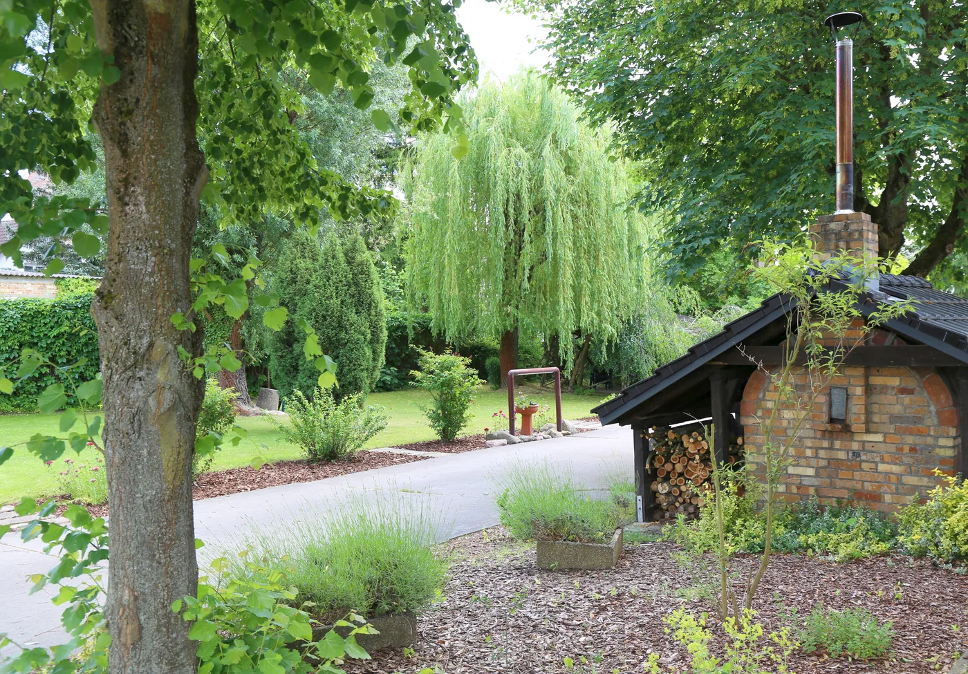 Backhaus zwischen alten Bäumen im Garten