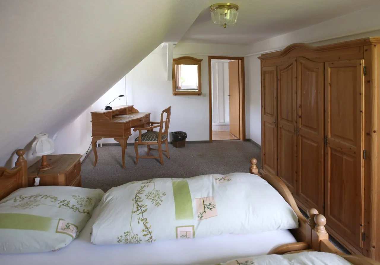 Geräumiges Zimmer unter dem Dach mit Holzschreibtisch