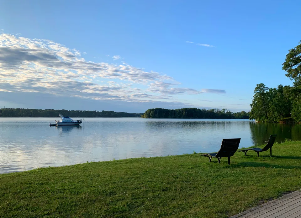Weiter Blick über den Scharmützelsee mit Boot und Uferwiese
